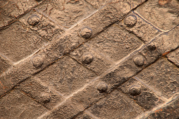 Background, texture. The image of the old metal painted brown door surface with slats and nails....