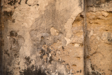 Natural abstract background. The texture of the old brown stone wall with chinks. Cropped shot, close-up, nobody, vertical. Concept of history and construction.