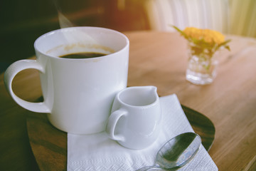 cup of hot coffee with foam and smoke on table in the morning. copyspace for your text