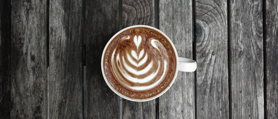 a cup of latte art coffee on wooden background        