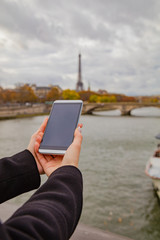 Girl using cellphone with Paris city background and Eiffel tower.
