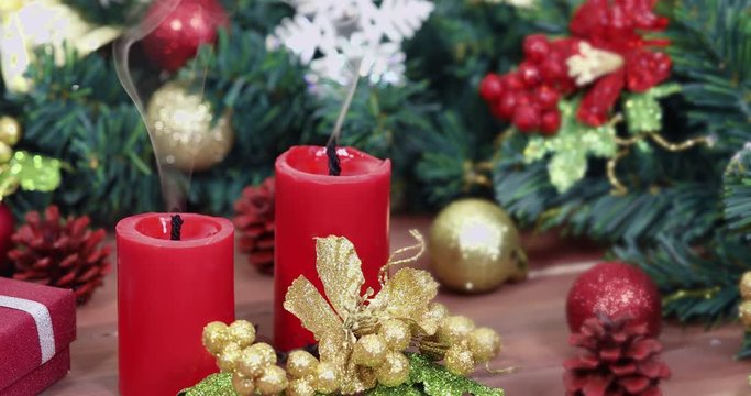 Close up scene VDO of snuff candles on wooden table, pine branches and gorgeous ornament on table, concept for Christmas festival.