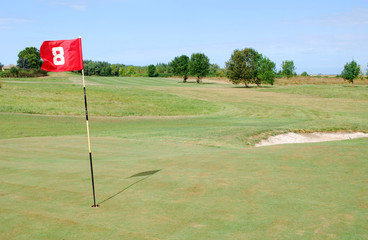 Obraz premium red flag number eight on golf course