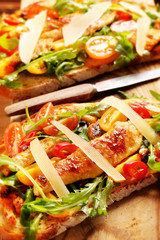 Chicken sandwich on fresh bread with arugula tomato and cheese