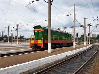 Diesel shunting locomotive of green and red colors stands near Peron. Tractor train of Soviet times. Infrastructure transport routes. Powerful machine assembly. Ucraine, Lviv, railway station.