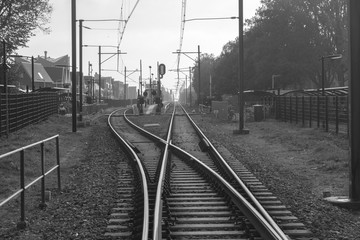 Railroad switch near a train station in a dutch town. Scenic view of a junction of railroad tracks. Black and White photograph.