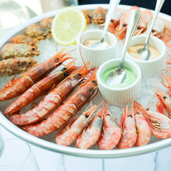 Assorted shrimps on ice with sauces