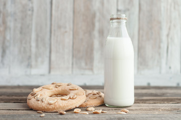 Milk in a glass bottle and homemade cookies on a wooden table top
