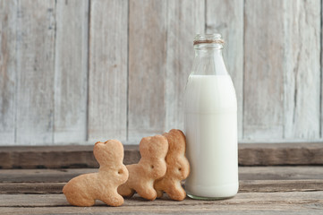 Milk in a glass bottle and homemade cookies on a wooden table top