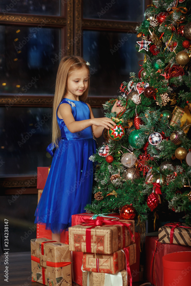 Wall mural little blonde girl in blue dress, new year