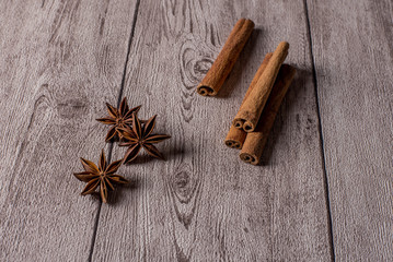 Cinnamon sticks and anise stars on wooden table.