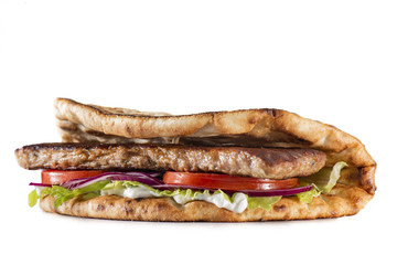 Greek pita with meat, salad, tomato and sauce isolated on white