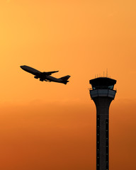 Air traffic control tower with a plane taking off at sunset. United Kingdom © PhotoEdit