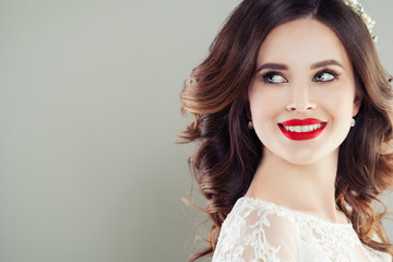 Cheerful young woman with red lips makeup and curly hair smiling. Beautiful female face