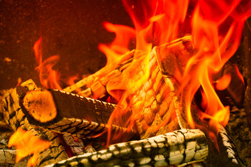 Burning wood logs, cooking on fire, warm evening, sparkles in the air, warm air from the fire