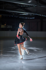A beautiful ice skater is ice skating on the ice.