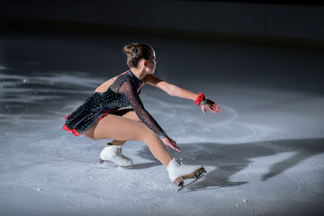 A young ice skater is spinning on the ice and she looks phenomenal.