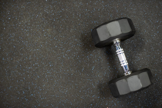 Dumbbell On Black Rubber Floor In Gym For Exercise.