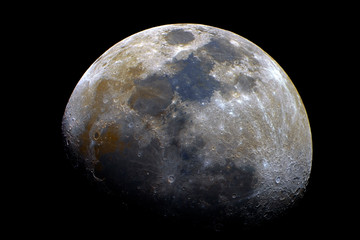 Waxing gibbous mineral Moon taken at 1500 mm with telescope, with its natural colors and craters details, isolated in dark background on space.