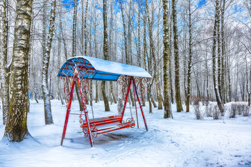 Empty swing in winter time with snow