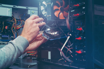 Technician repairing a computer, the process of replacing components on the motherboard. The technician hold the screwdriver for repairing PC. The concept of computer hardware, upgrade and technology