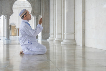 Middle age muslim man praying at mosque.