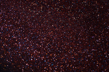 Blurred shiny dark red background with sparkling lights.