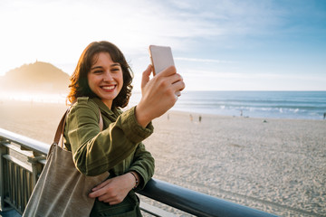 Naklejka premium Happy tourist woman taking selfie with her smart phone