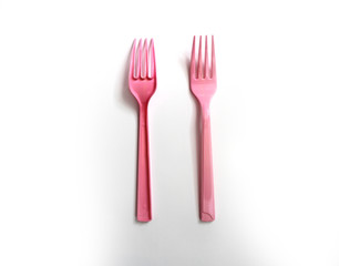 Pink plastic forks on a white background. Front and back face