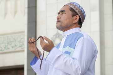 Middle age muslim man praying at mosque.