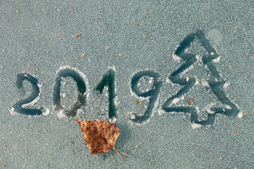 The inscription 2019 and the drawing of the Christmas tree on the glass by hoarfrost.