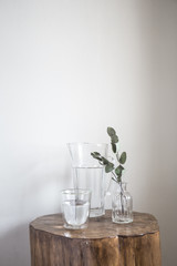 Nice still life and decoration with glass jar of water and eucalyptus plant in a wood small table