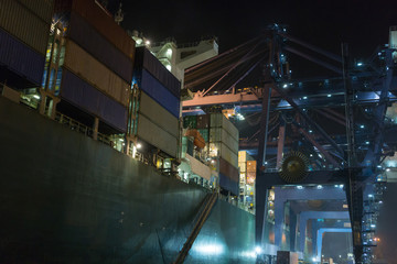 Container ship in port at container terminal in fog weather. Ships of container ships stand in terminal of port on loading, unloading container at night