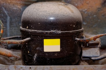  Old dusty compressor in a refrigerator.