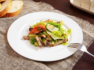 Salad on a plate on a wooden table