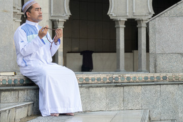 Middle age muslim man praying at mosque.