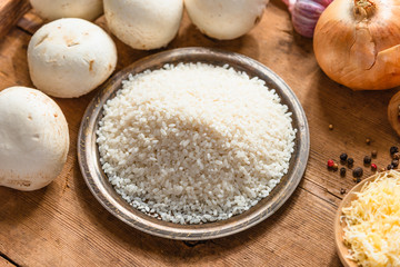 Ingredients for risotto - rice, mushrooms, onions, garlic and grated cheese