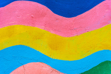 Rainbow painted concrete wall close up