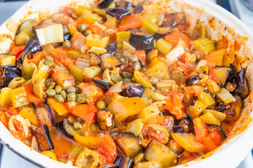 Cooking caponata in a large frying pan