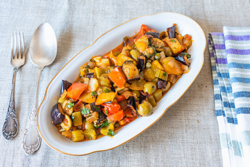 Italian cuisine - caponata on a plate on a rustic background