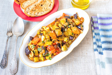 Italian cuisine - caponata on a plate on a rustic background