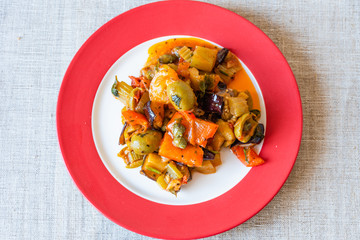 Caponata siciliana on a beautiful plate close-up, top view
