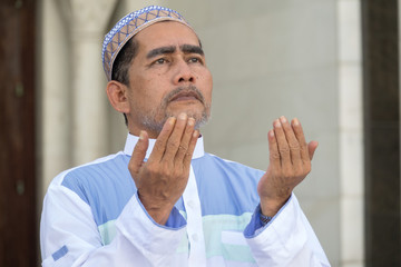 Middle age muslim man praying at mosque.