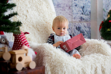 Fototapeta premium Little baby toddler boy, playing with christmas decoration at home, studio shot