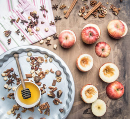 Ingredients for cooking baked apples with nuts and honey are on the tablecloth and in the baking dish, on a rustic background, a place for text.