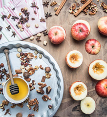 Ingredients for cooking baked apples with nuts and honey are on the tablecloth and in the baking dish, on a rustic background, a place for text.
