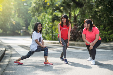 young cheerish asian woman  excecise in a park at morning