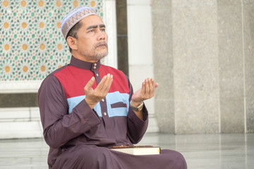 Middle age muslim man praying at mosque.