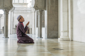 Middle age muslim man praying at mosque.