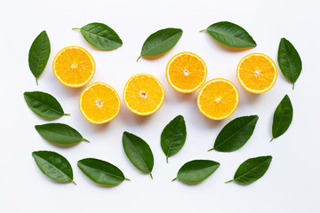 Top view of orange fruits  and  green leaves on white background.
